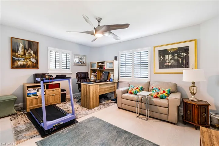 Office with a ceiling fan and baseboards