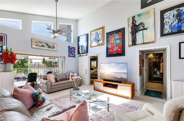 Living room featuring ceiling fan and a high ceiling