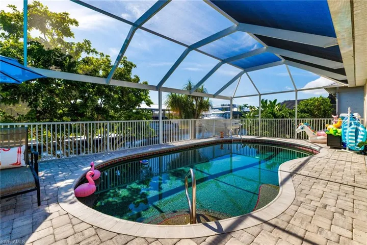 View of swimming pool with a patio, glass enclosure, and a fenced backyard