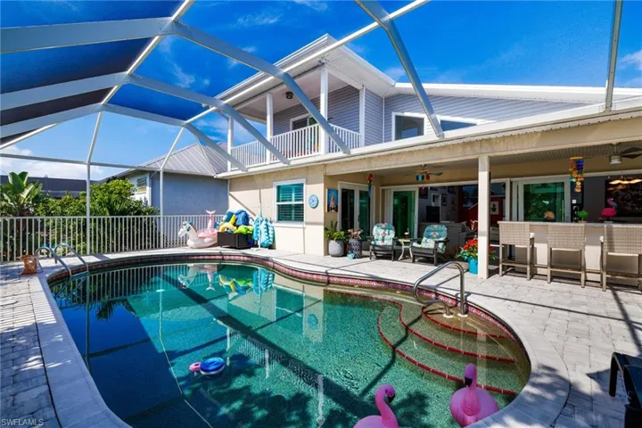 Swimming pool with a patio, ceiling fan, and glass enclosure