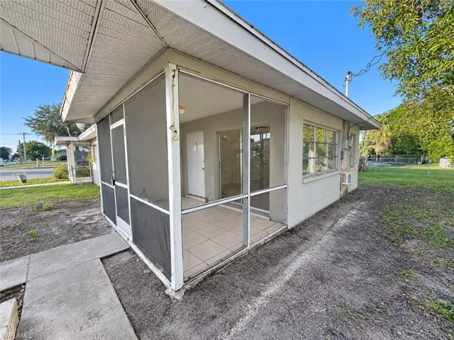 Screened-in porch featuring ceramic tile flooring, aluminum framing, and sliding glass entry doors