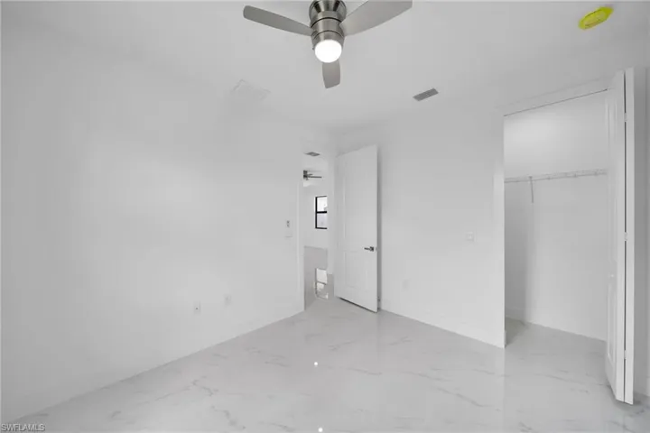 Unfurnished bedroom featuring a closet, ceiling fan, and light tile patterned floors