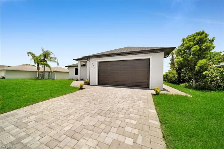 View of front of property with a garage and a front yard