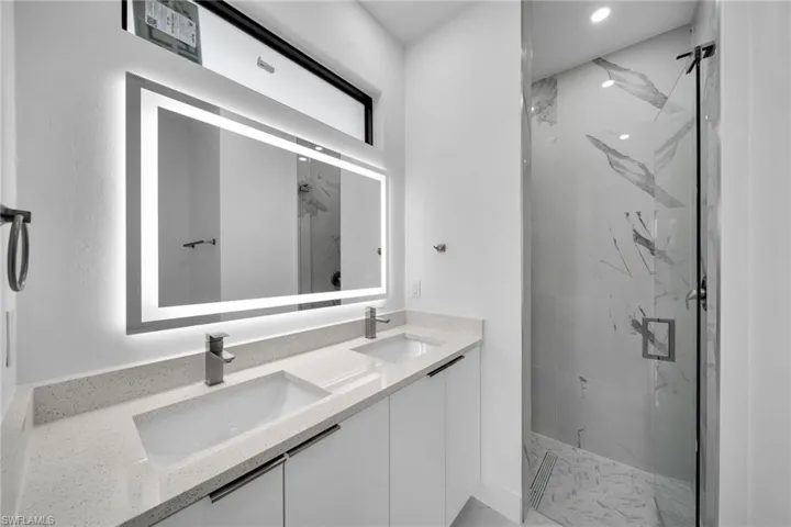 Bathroom featuring walk in shower and double sink vanity
