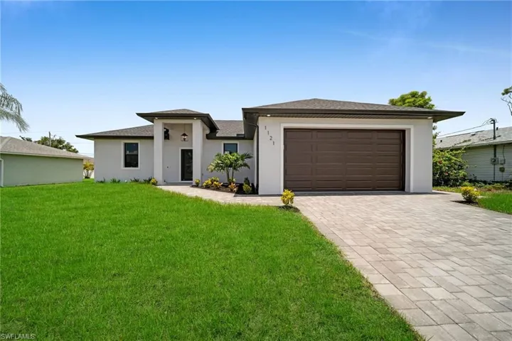 View of front of house featuring a garage and a front yard