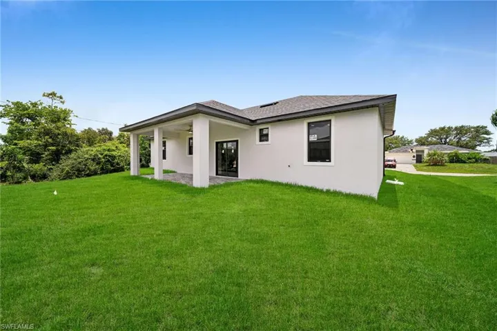 Rear view of property with a yard