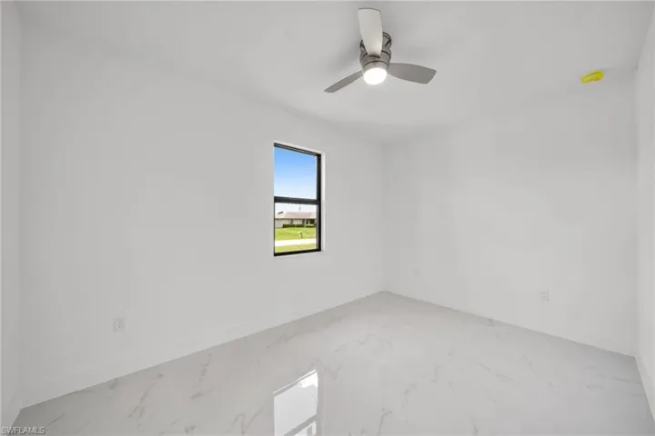 Unfurnished room featuring ceiling fan and tile patterned flooring