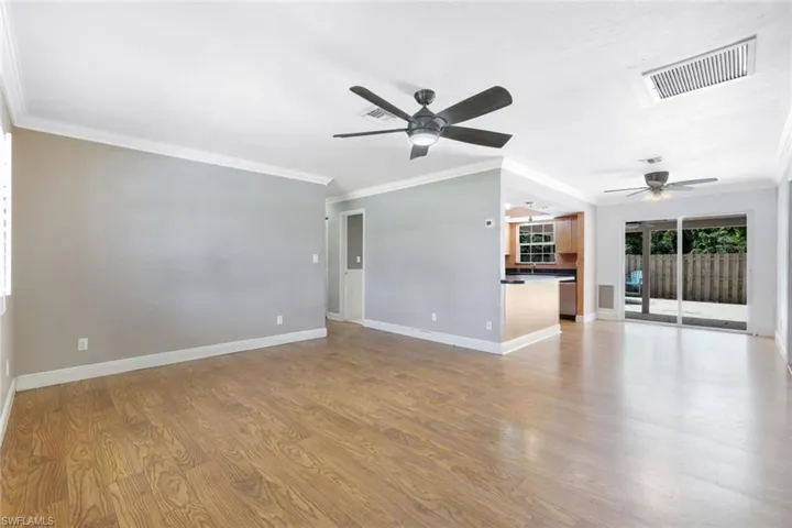 Unfurnished living room featuring sink, ornamental molding, ceiling fan, and light hardwood / wood-style floors