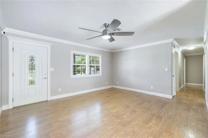 Foyer entrance with crown molding, ceiling fan, and hardwood / wood-style floors