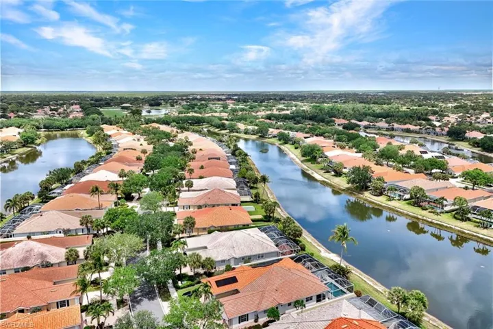 Aerial perspective showcasing a residential community with numerous homes featuring terra cotta tile roofs