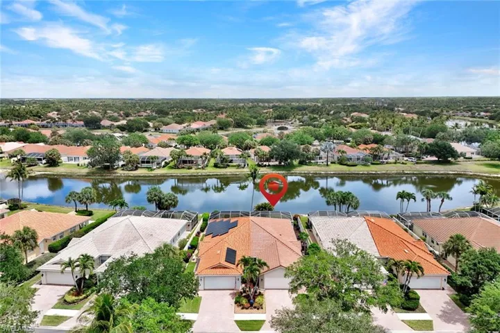 Aerial perspective showcasing a residential community with numerous properties situated along a waterway