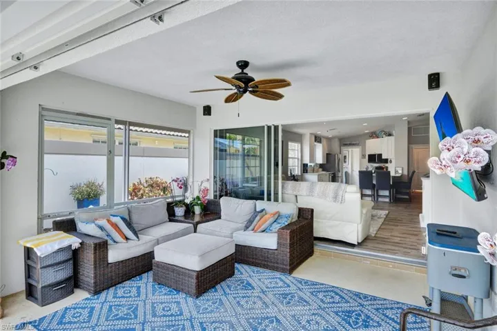 Screened patio featuring a ceiling fan, recessed lighting, and large sliding glass doors opening to an interior space with wood-finish flooring