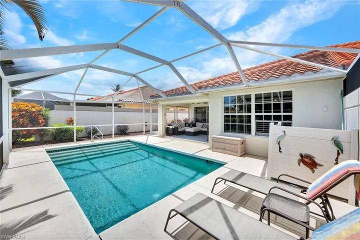 Screened-in swimming pool with a concrete paver deck and an adjacent covered patio area