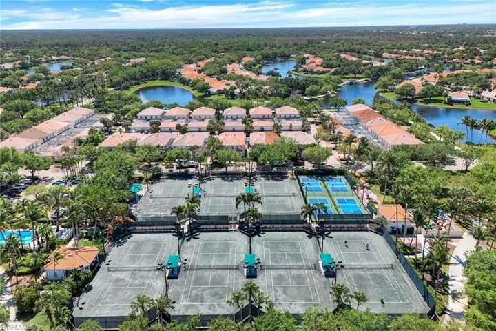Eight tennis courts, including four blue hardcourts and four green hardcourts, surrounded by lush landscaping