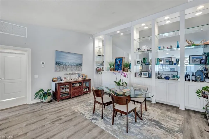 Dining area featuring wood-finish flooring, a contemporary area rug, and a white paneled door