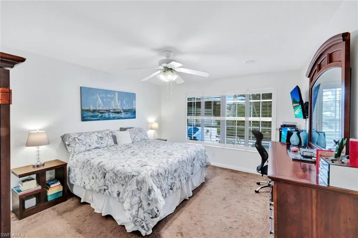 Spacious room featuring white walls, carpeting, and a ceiling fan with integrated lighting