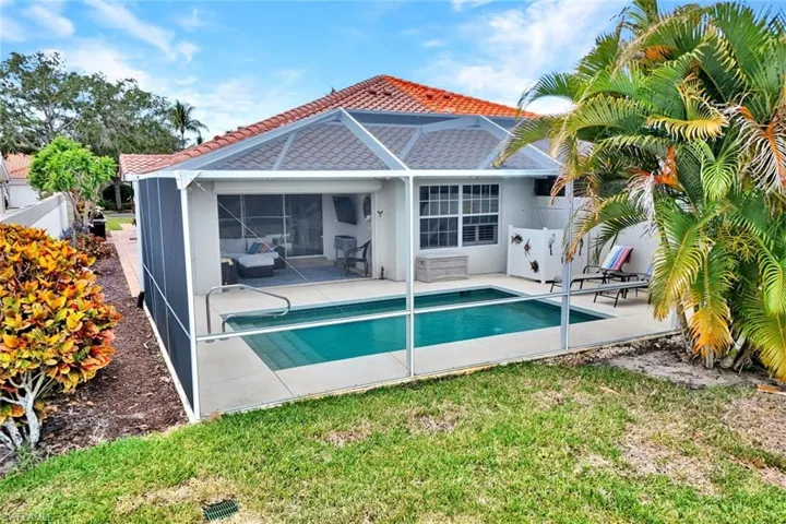 Screened pool area featuring a rectangular swimming pool with integrated steps, a paver patio surround, and a covered lanai