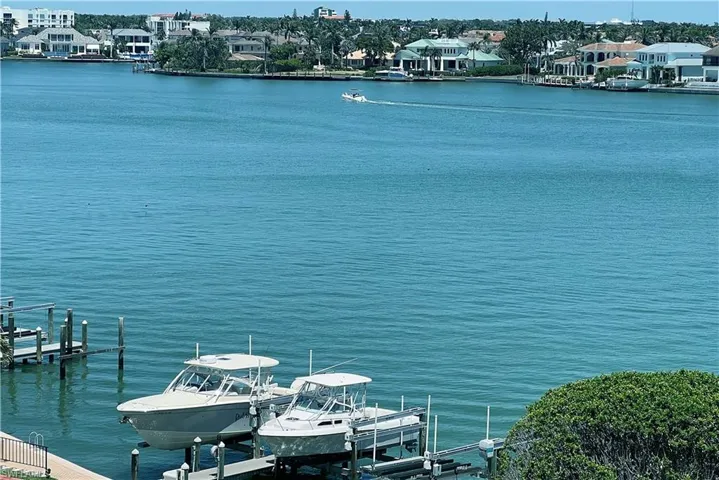 View of dock with boat lift and a water view from kitchen window