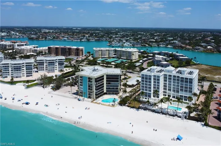 Birds eye view of property featuring a view of the beach and a water view
