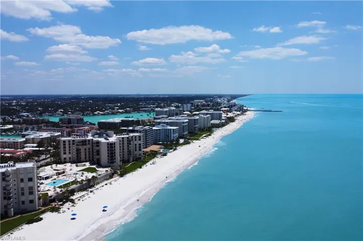 Birds eye view of property featuring a view of city, a beach view, and a water view