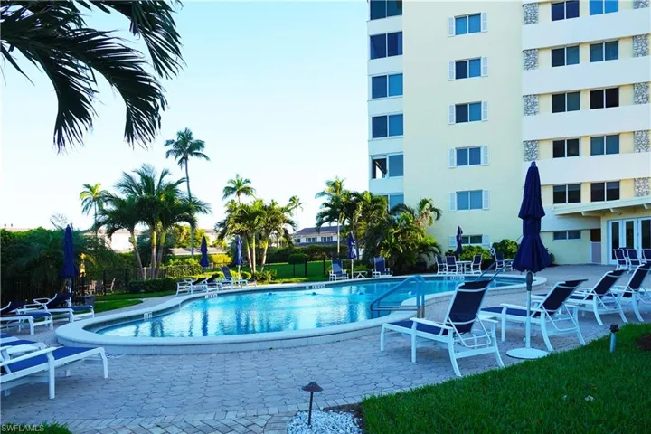 Community pool featuring fence and a patio area