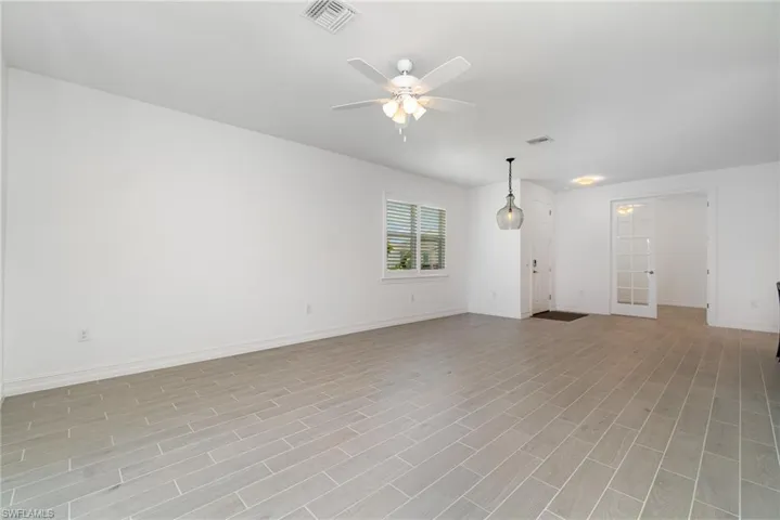 Empty room with ceiling fan and light wood finished floors