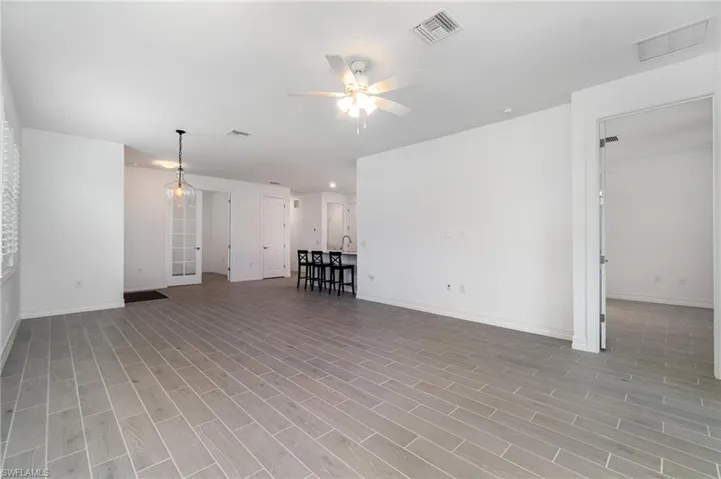 Unfurnished living room featuring a ceiling fan and light wood-style floors