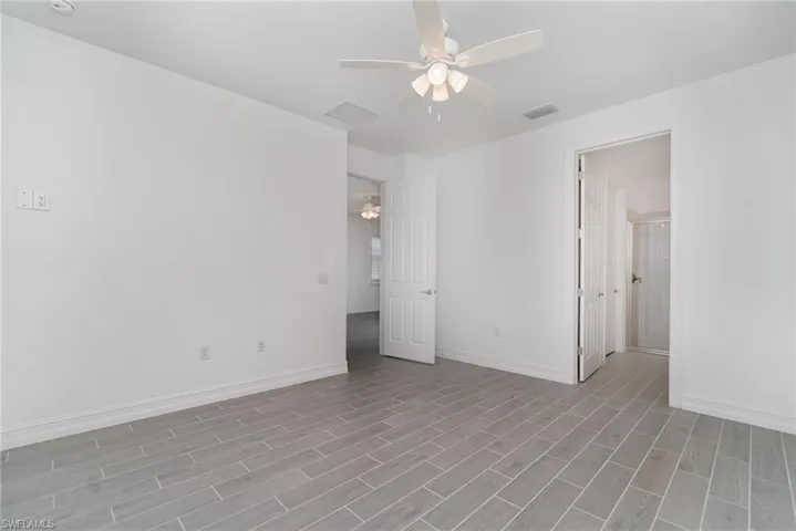 Unfurnished room featuring a ceiling fan and wood finished floors