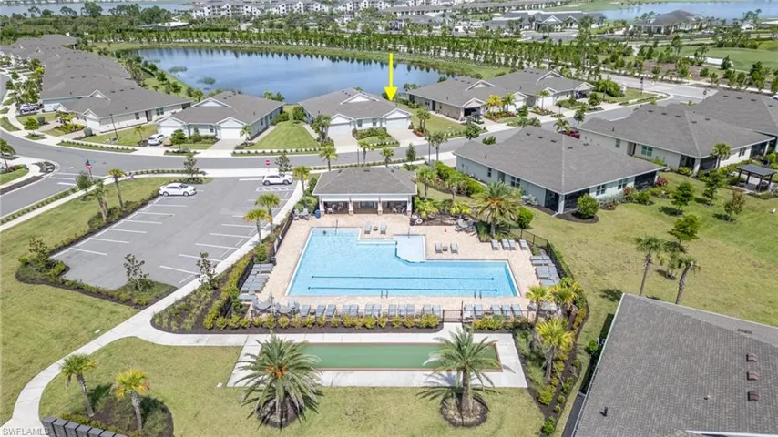 Aerial perspective of suburban area featuring a nearby body of water and a pool