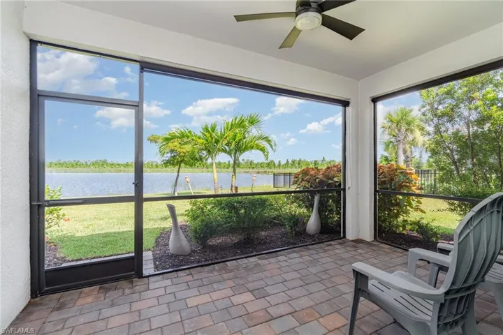 Sunroom featuring a water view and ceiling fan