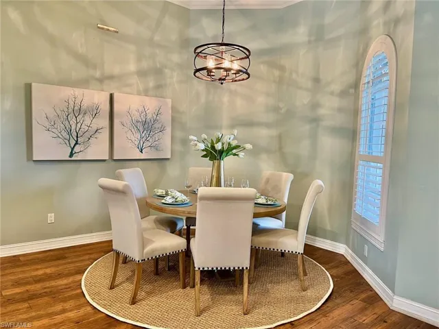 Dining area featuring a notable chandelier, dark hardwood / wood-style flooring, and crown molding