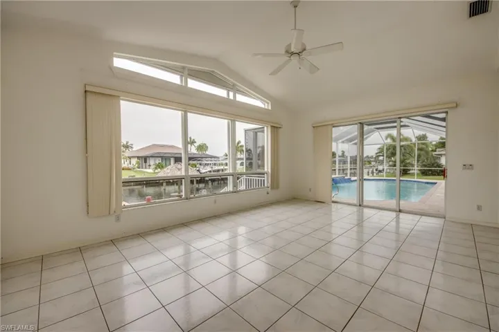 Tiled Family room featuring ceiling fan and lofted ceiling