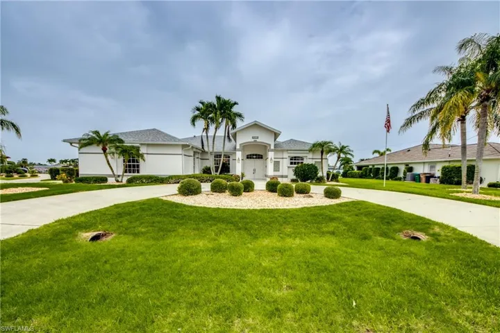 View of front of home featuring a garage and a front lawn, side load garage to the left with another wide driveway