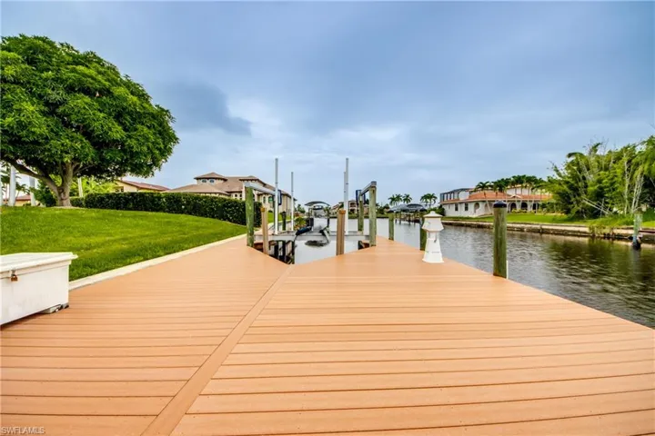 Dock area with a water view and a yard