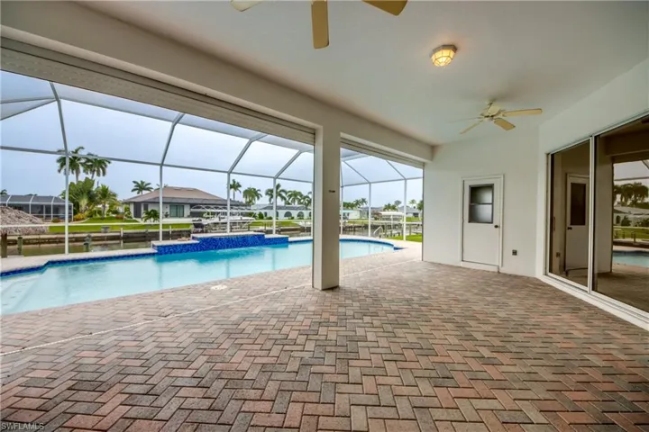 View of swimming pool with a lanai, a patio area, and ceiling fan