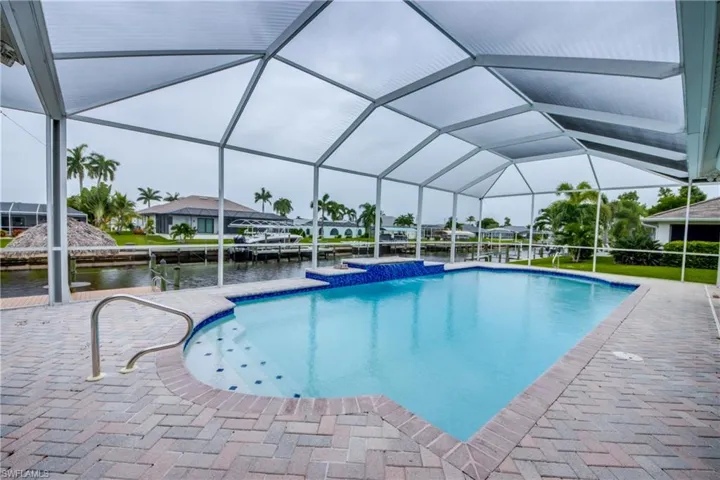 View of pool with a boat dock and a lanai