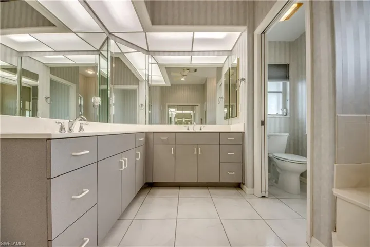 Bathroom featuring vanity, tile patterned flooring, and toilet with Two Sinks