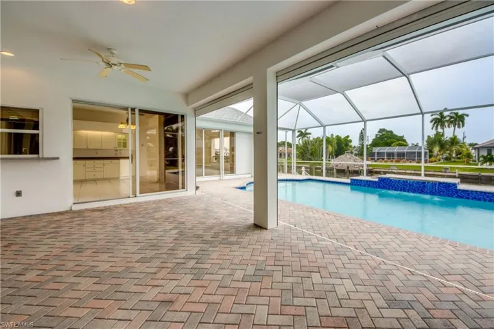 View of swimming pool with pool water feature and ceiling fan