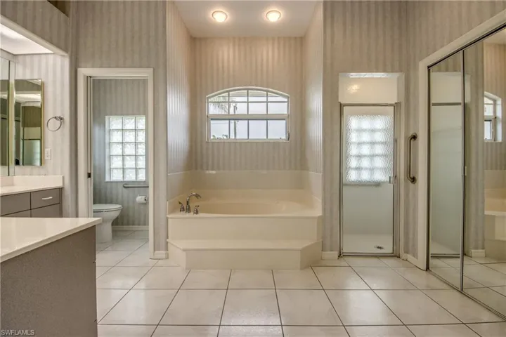 Full bathroom featuring vanity, toilet, tile patterned floors, and shower with separate bathtub. Large Linen Closet to the Right