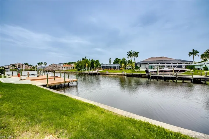 View of dock with a water view and a yard