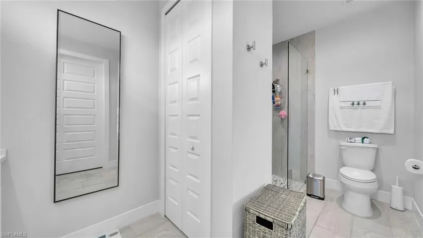 Bathroom featuring a shower stall and a closet