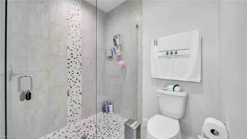 Full bathroom with a stall shower and toilet