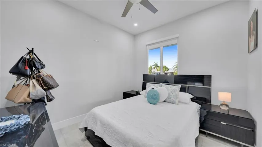 Bedroom with a ceiling fan, recessed lighting, and light marble finish floors