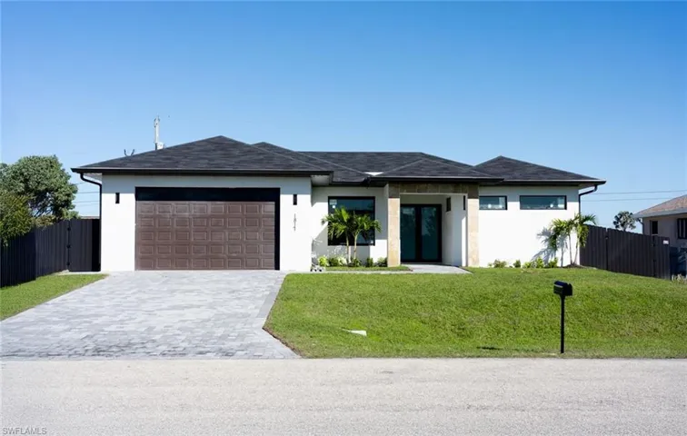 View of front of home with a garage and a front yard