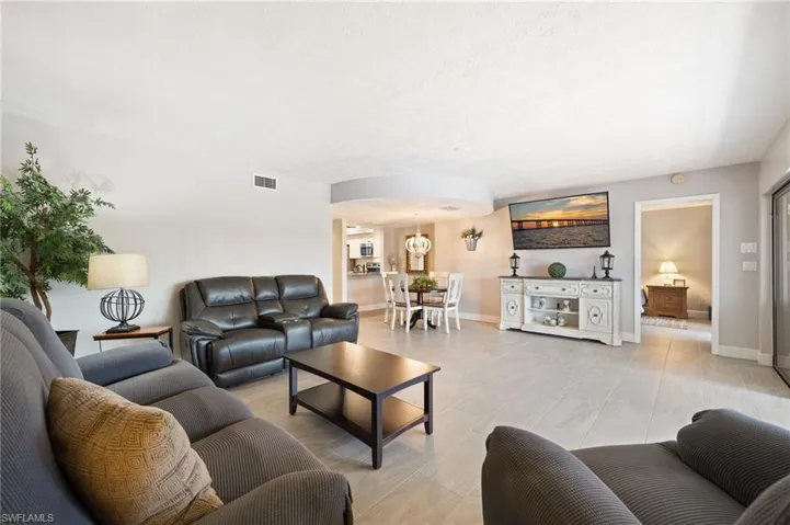 Open-concept living area with light-colored tile flooring