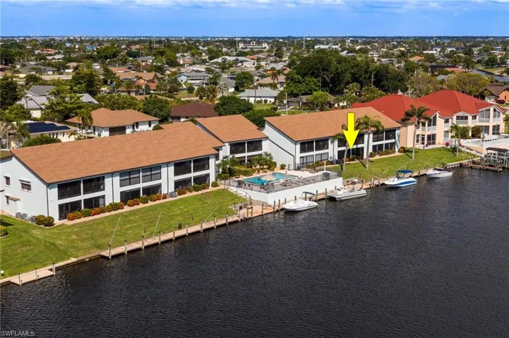 Waterfront multi-story residence featuring a private boat dock, a dedicated swimming pool area, and multiple balconies