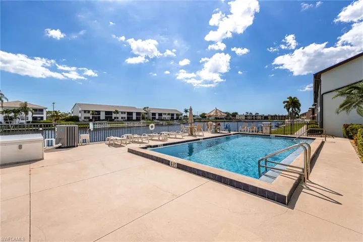 Outdoor swimming pool with integrated steps and handrails, surrounded by a spacious concrete deck