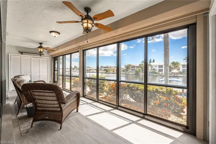 Enclosed porch with full-height windows overlooking a canal