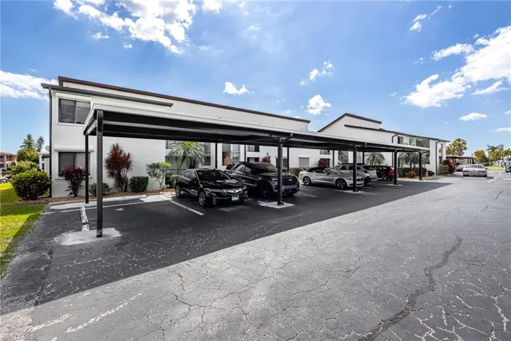 Covered parking area featuring multiple carports with dark frames and white roofs