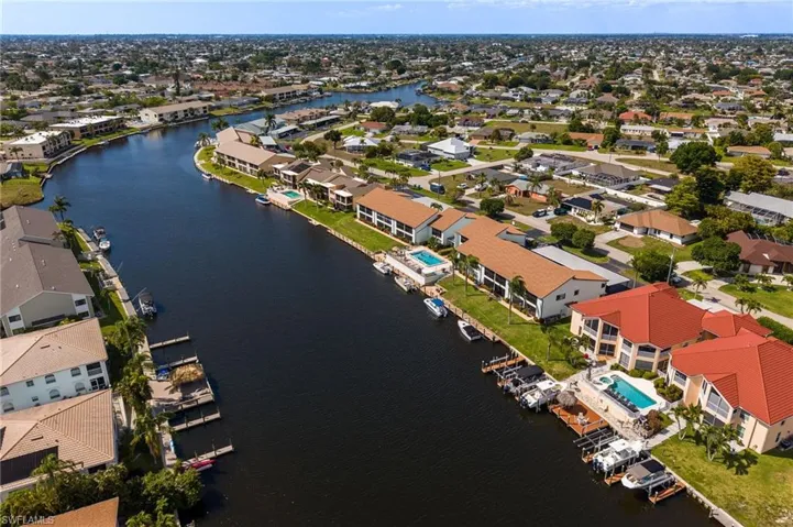 Waterfront community featuring canal access, private docks, mature landscaping, and residential architecture